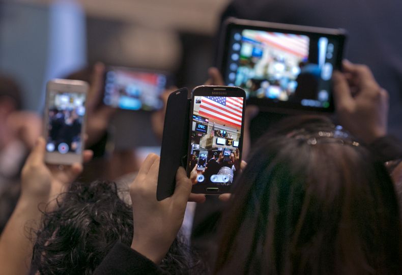 Visitantes de la bolsa de Nueva York usan sus tel&eacute;fonos inteligentes y tabletas para fotografiar la apertura de la jornada de contrataci&oacute;n el lunes, 4 de noviembre del 2014. La confianza en Twitter parece haber aumentado antes de su oferta p
