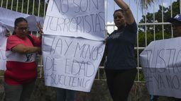 Familiares de los detenidos sostienen carteles afuera de la cárcel de Tocuyito donde están detenidos en Pocaterra, Venezuela, el lunes 26 de agosto de 2024. Los detenidos fueron arrestados mientras protestaban contra los resultados de las elecciones presidenciales. (AP Foto/Jacinto Oliveros)