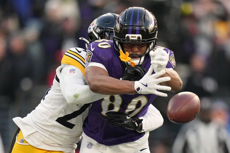 Joey Porter Jr. (24), de los Steelers de Pittsburgh, le tumba el balón de las manos a Isaiah Likely (80), ala cerrada de los Ravens de Baltimore, durante la segunda mitad del partido e la NFL del domingo 7 de diciembre de 2025, en Baltimore. (AP Foto/Stephanie Scarbrough)
