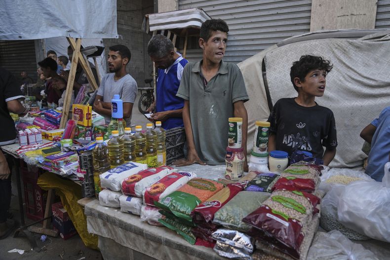 Vendedores palestinos muestran mercancías a la venta en un mercado callejero en Ciudad de Gaza, el miércoles 23 de julio de 2025. (AP Foto/Jehad Alshrafi)