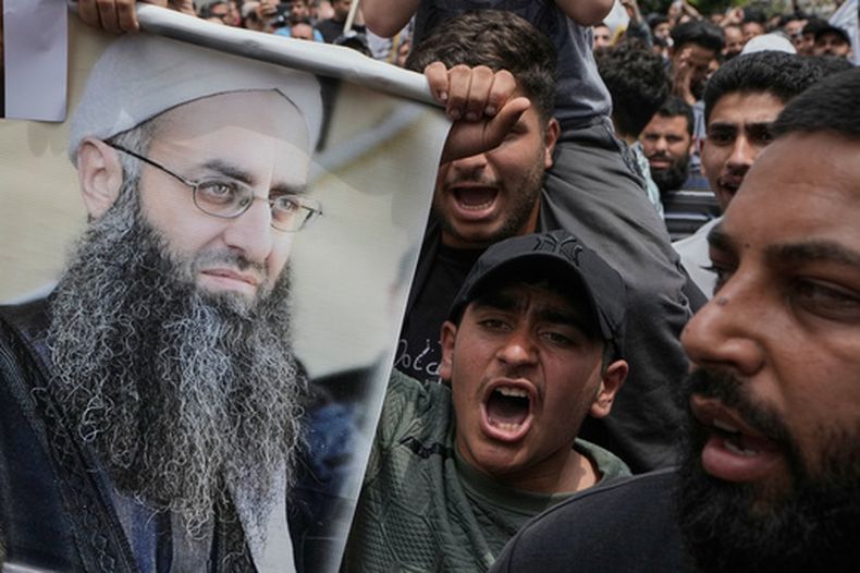 ARCHIVO - Musulmanes suníes sostienen un retrato del clérigo suní encarcelado Ahmad al-Assir durante una protesta contra una cláusula de un proyecto de ley de amnistía —que excluye a algunos reclusos, incluido el clérigo, de poder acogerse a dicha medida—, tras las oraciones del viernes en Beirut, Líbano, el viernes 22 de mayo de 2026. (Foto AP/Bilal Hussein, archivo)