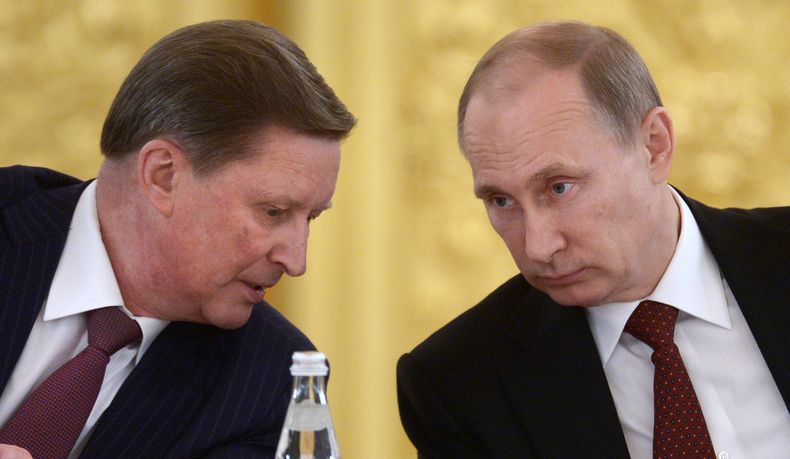 Sergei Ivanov, jefe de personal del Kremlin, habla con el presidente ruso Vladimir Putin durante un acto pol&iacute;tico en Mosc&uacute;, el lunes 24 de marzo de 2014. (Foto AP/RIA-Novosti, Alexei Nikolsky, Presidential Press Service)