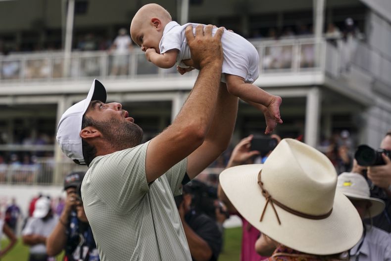 Scottie Scheffler sostiene a su hijo Bennett en el hoyo 18 tras la última ronda del Tour Championship el domingo primero de septiembre del 2024. (AP Foto/Jason Allen)