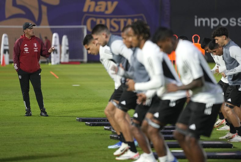 El técnico de Perú Juan Reynoso (izquierda) dirige un entrenamiento previo a las eliminatorias del Mundial, el lunes 9 de octubre de 2023, en Lima. Perú enfrentará a Chile el jueves. (AP Foto/Martín Mejía) Perus national soccer team coach Juan Reynoso, left, leads a training session in Lima, Peru, Monday, Oct. 9, 2023. Peru will face Chile in a World Cup 2026 qualifying soccer match in Santiago, Chile on Oct.12. (AP Photo/Martin Mejia)