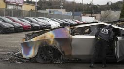 ARCHIVO - Un miembro del departamento de bomberos de Seattle inspecciona un Tesla Cybertruck en un estacionamiento de Tesla en Seattle, el lunes 10 de marzo de 2025. (AP Foto/Lindsey Wasson, Archivo)