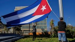 Trabajadores ondean la bandera cubana a media asta en la Tribuna Antiimperialista, cerca de la embajada de Estados Unidos en La Habana, Cuba, el lunes 5 de enero de 2026, en memoria de los cubanos fallecidos dos días antes en Caracas, Venezuela, durante la captura del presidente venezolano Nicolás Maduro por fuerzas estadounidenses. (Foto AP/Ramón Espinosa)