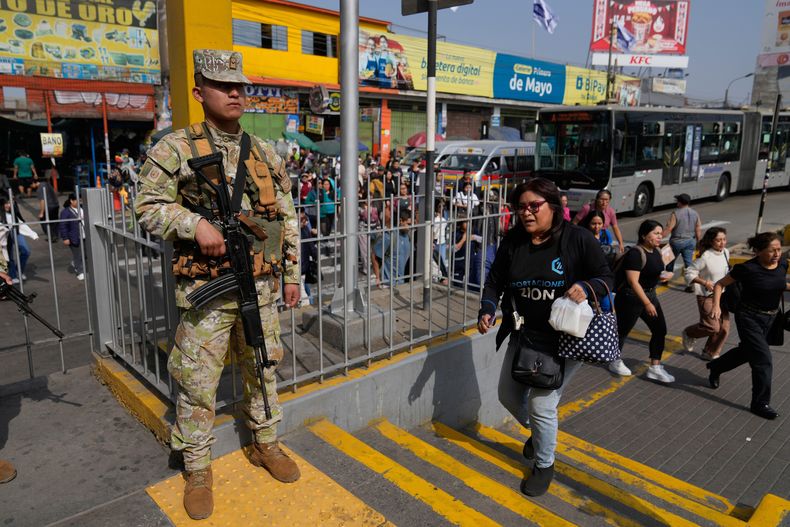Un soldado hace guardia en una parada de autobús en Lima, Perú, el miércoles 22 de octubre de 2025, después de que el presidente José Jerí declarara el estado de emergencia. (AP Foto/Martín Mejía)