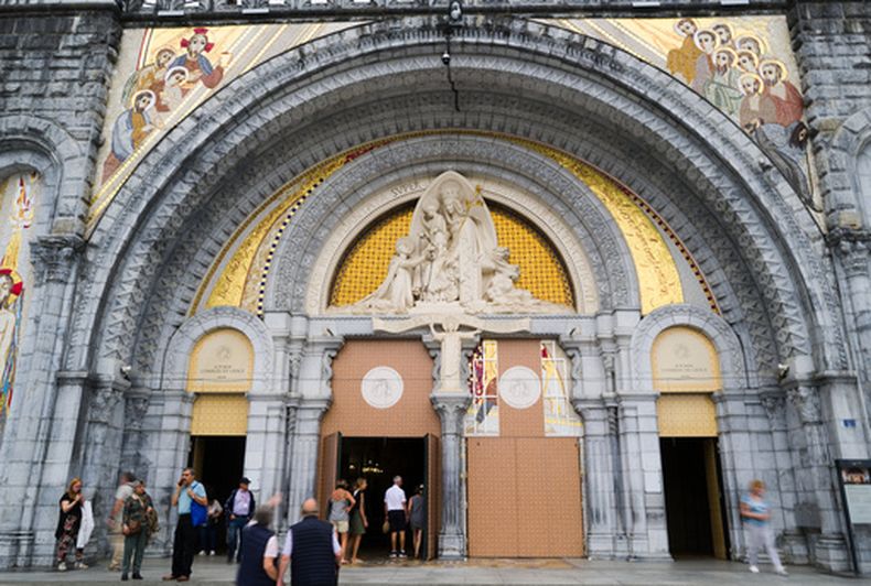 Varias personas entran en la basílica de Nuestra Señora del Rosario en Lourdes, en el suroeste de Francia, el 8 de septiembre de 2026. (AP Foto/Fred Scheiber)