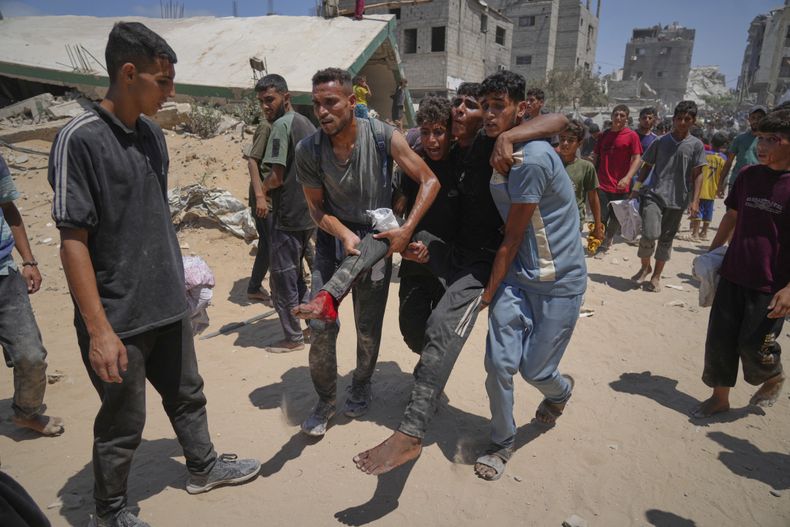 Palestinos trasladan a un hombre herido mientras trataba de conseguir ayuda humanitaria lanzada por aire sobre la Ciudad de Gaza, en el norte de la Franja de Gaza, el 7 de agosto de 2025. (AP Foto/Jehad Alshrafi)