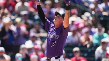 TJ Rumfield, de los Rockies de Colorado, hace un gesto al cruzar el plato tras conectar un jonrón de dos carreras ante el lanzador relevista de los Rojos de Cincinnati, Caleb Ferguson, en la sexta entrada de un partido de béisbol el sábado 18 de julio de 2026, en Denver. (Foto AP/David Zalubowski)