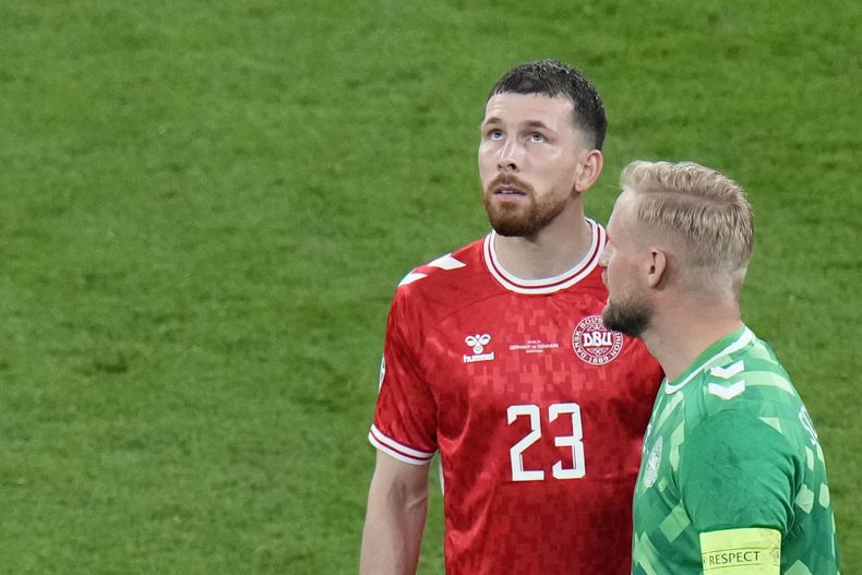 El danés Pierre-Emile Hojbjerg, a la izquierda, mira hacia el techo del estadio durante un partido de octavos de final entre Alemania y Dinamarca en la Eurocopa 2024 en Dortmund, Alemania, el sábado 29 de junio de 2024. (AP Foto/Hassan Ammar)