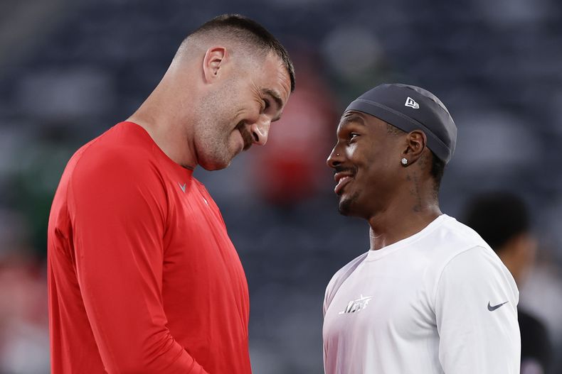 Travis Kelce (izquierda) charla con Mecole Hardman Jr., su compañero de los Chiefs de Kansas City, antes de un partido realizado el domingo 1 de octubre de 2023 (AP Foto/Adam Hunger)