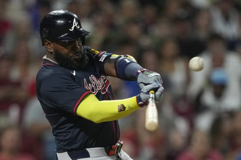 El bateador designado de los Bravos de Atlanta, Marcell Ozuna, conecta un elevado de sacrificio para que Matt Olson anote durante la décima entrada de un partido de béisbol contra los Rojos de Cincinnati, el jueves 31 de julio de 2025, en Cincinnati. (AP Photo/Carolyn Kaster)
