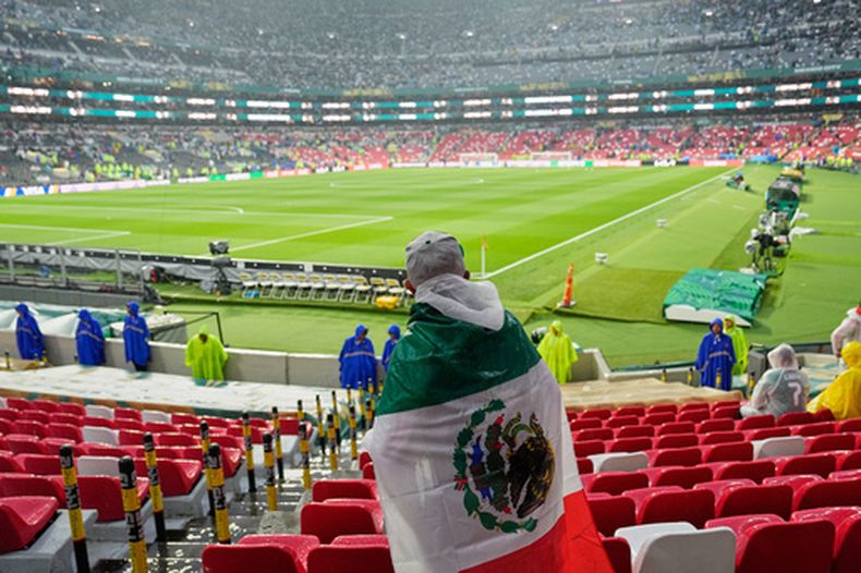 Un aficionado espera bajo la lluvia el inicio del partido entre México y Ecuador en los 18vos de final del Mundial, el martes 30 de junio de 2026, en la Ciudad de México. (AP Foto/Natacha Pisarenko )