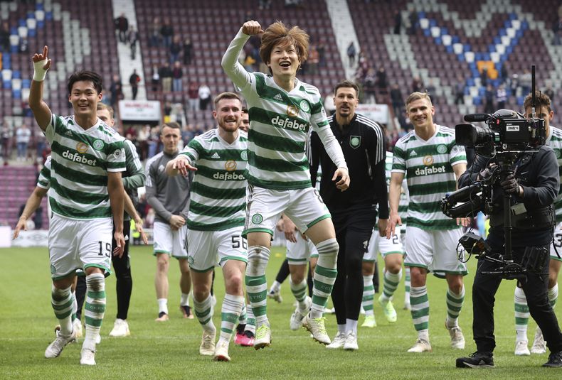 Kyogo Furuhashi (primer plano) festeja luego que Celtic aseguró el título de la liga escocesa tras el partido contra Hearts, el domingo 7 de mayo de 2023, en Edinburgo. (Steve Welsh/PA vía AP)