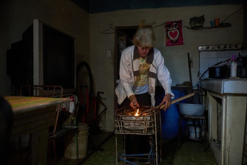 Minorkys Hoyos Ruiz enciende carbón para cocinar la cena el martes 3 de febrero de 2026, durante un apagón programado con el fin de racionar la energía en Santa Cruz del Norte, sede de una de las centrales termoeléctricas más grandes de Cuba. (AP Foto/Ramón Espinosa)