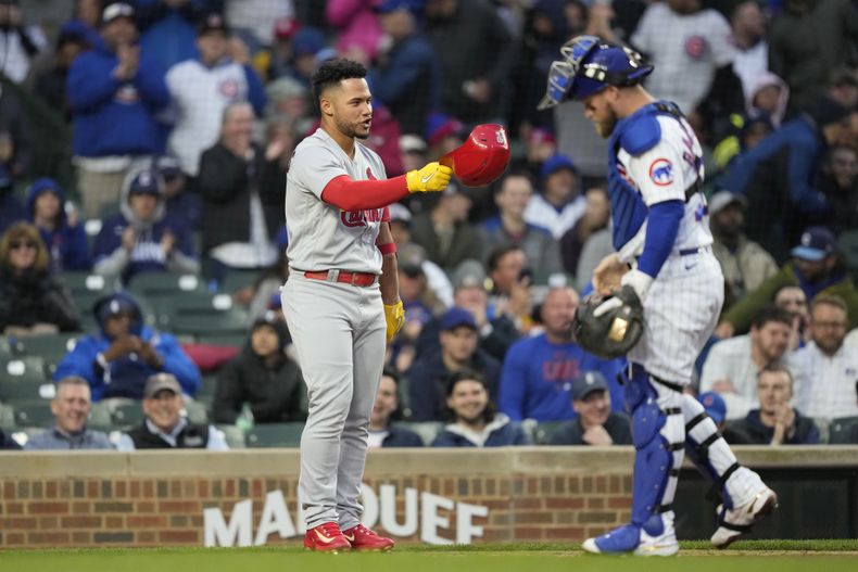 Willson Contreras de los Cardenales de San Luis se quita su casco frente al cátcher de los Cachorros de Chicago Tucker Barnhart en el encuentro del lunes 8 de mayo del 2023. (AP Foto/Charles Rex Arbogast)
