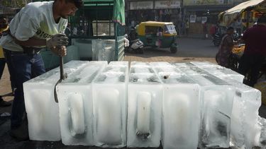ARCHIVO - Un hombre coloca bloques de hielo en un puesto para su venta, en Ahmedabad, India, el 2 de abril de 2025. (AP Foto/Ajit Solanki, archivo)