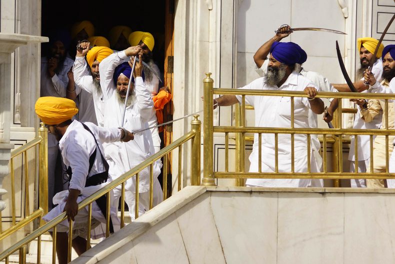 Sijs chocan con guardias en el santuario m&aacute;s sagrado de su fe, el Templo Dorado en Amritsar, India, viernes 6 de junio de 2014. El choque, que dej&oacute; seis heridos, se produjo durante una ceremonia conmemorativa de la toma del templo por el ej&