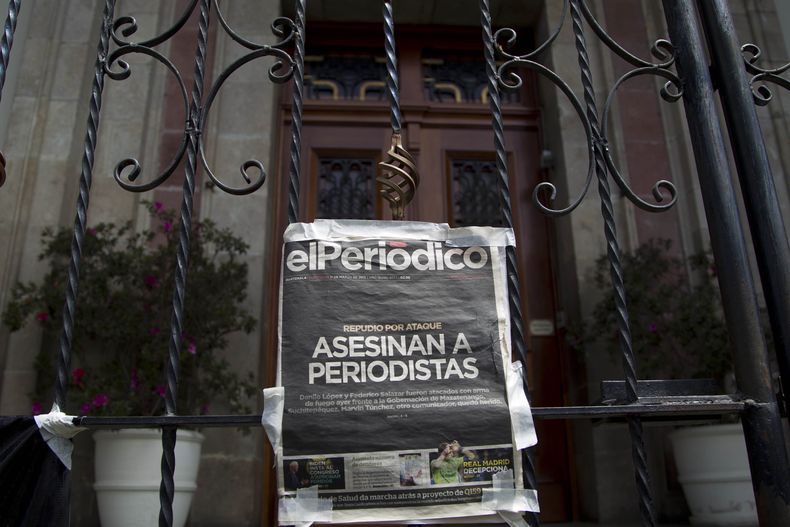 ARCHIVO - Un ejemplar del periódico El Periódico de Guatemala que dice Periodistas asesinados cuelga en la puerta de la Casa Presidencial durante una protesta para exigir una investigación sobre el asesinato de dos periodistas y mayor seguridad para la profesión en la Ciudad de Guatemala, el 11 de marzo de 2015. Las publicaciones digitales de medios de comunicación centroamericanos serán resguardadas bajo un programa llamado Archivo Independiente de Medios de Centroamérica (CAIMA) financiado por la Agencia de los Estados Unidos para el Desarrollo Internacional (USAID) se anunció el miércoles 4 de diciembre de 2024. (Foto AP/Moises Castillo, Archivo)