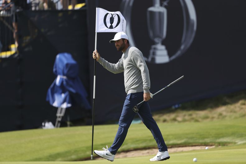 El estadounidense Scottie Scheffler sostiene el banderín del green 17 durante una práctica antes del Abierto Británico el lunes 14 de julio del 2025. (AP Foto/Peter Morrison)