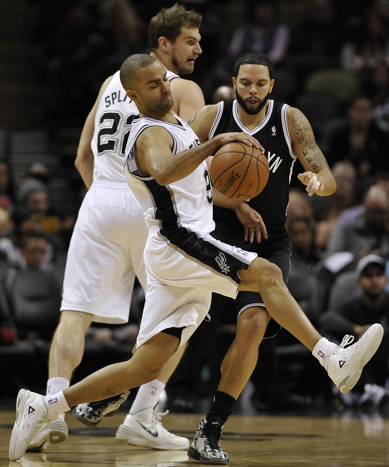 El franc&eacute;s Tony Parker, de los Spurs de San Antonio, recupera el bal&oacute;n luego de chocar con Deron Williams, escolta de los Nets de Brooklyn, en el partido del martes 31 de diciembre de 2013 (AP Foto/Darren Abate)
