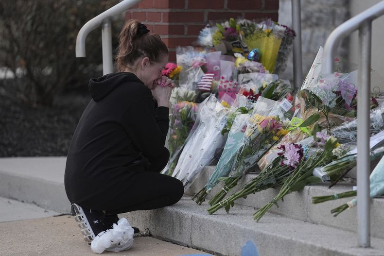 Linda Shields deja flores frente al Departamento de Policía del distrito de West York después de que un policía fue asesinado al responder a un tiroteo en el hospital UPMC Memorial, el sábado 22 de febrero de 2025, en York, Pensilvania. (AP Foto/Matt Rourke)