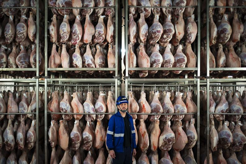 Víctor Razuri, de 41 años y originario de Perú, posa en una planta de secado de jamón en Guissona, Lleida, España, el jueves 20 de febrero de 2025. (AP Foto/Joan Mateu Parra)