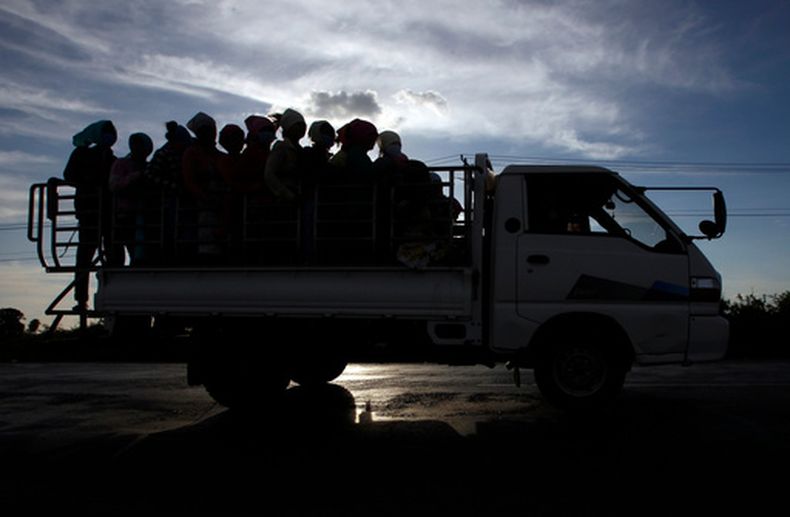 ARCHIVO - En esta fotografía del 3 de diciembre de 2018, trabajadores de una fábrica de ropa viajan en un camión de regreso a casa después de una jornada laboral en las afueras de Nom Pen, Camboya. (AP Foto/Heng Sinith, archivo)
