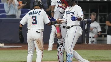El cubano Jorge Soler, bateador designado de los Marlins de Miami, es felicitado por su compañero, el venezolano Luis Arráez, luego de conectar un jonrón de dos carreras el miércoles 17 de mayo de 2023 (AP Foto/Marta Lavandier)