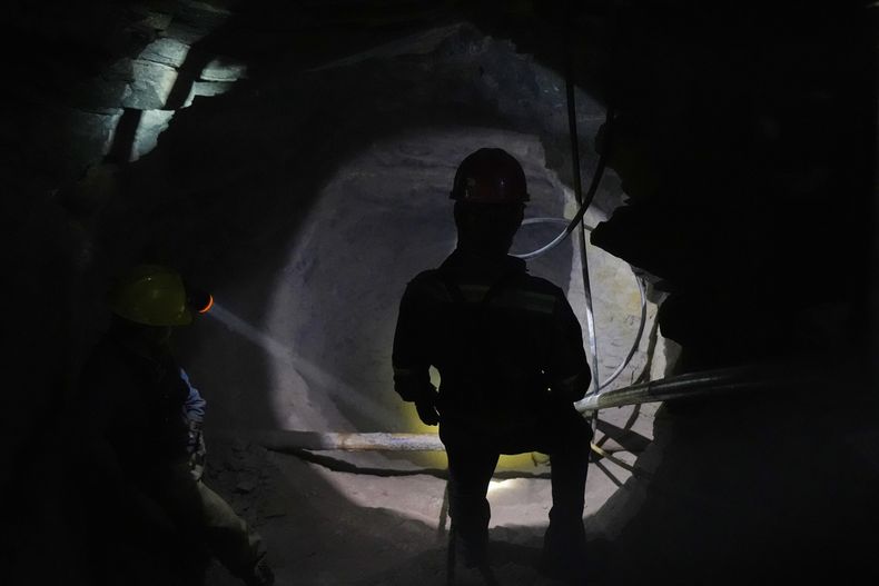 Un minero ilumina una de las cavernas para que sus compañeros puedan ver la salida, en San Joaquín, México, el martes 19 de agosto de 2025. (AP Foto/Fernando Llano)