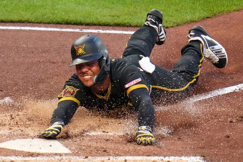 Esmerlyn Valdez, de los Piratas de Pittsburgh, se barre en el plato y anota una carrera con un sencillo de Rafael Flores Jr. frente al lanzador Jake Bennett, de los Medias Rojas de Boston, durante la cuarta entrada del juego de béisbol de Grandes Ligas, el viernes 14 de agosto de 2026. (AP Foto/Gene J. Puskar)