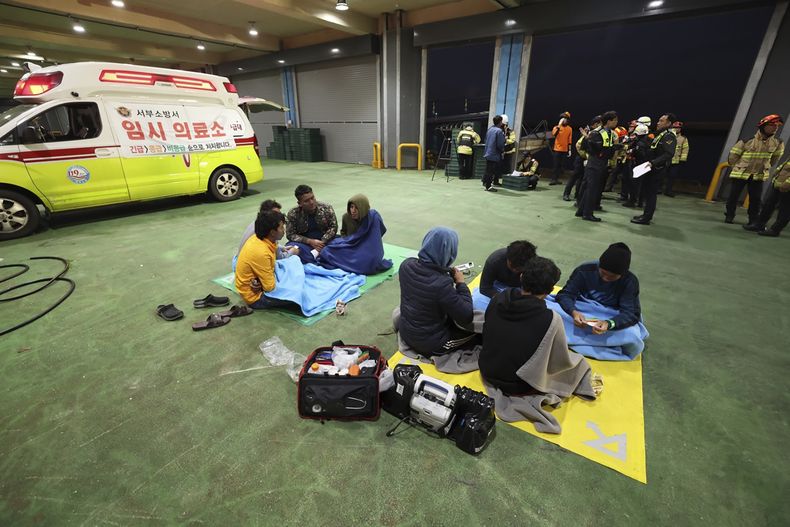 Miembros de la tripulación de un buque pesquero que naufragó esperan en un puerto de la isla de Jeju, en Corea del Sur, para ser llevados a un hospital, el viernes 8 de noviembre de 2024. (Park Ji-ho/Yonhap vía AP)