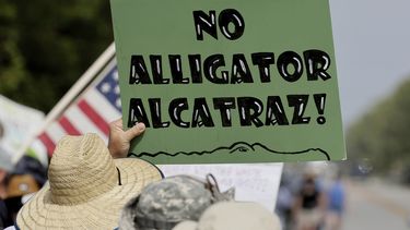 Defensores del medio ambiente y manifestantes en el Aeropuerto de Entrenamiento y Transición de Dade-Collier en el Sendero Tamiami E, Ochopee, Florida, el sábado 28 de junio de 2025, se oponen al Alcatraz de los caimanes que se construye en la instalación. (Mike Stocker /South Florida Sun-Sentinel vía AP)