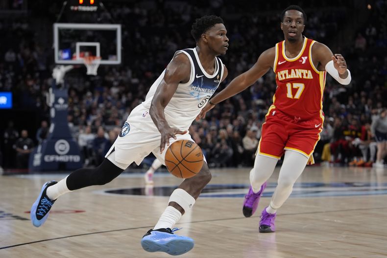 El base de los Timberwolves de Minnesota Anthony Edwards avanza hacia la canasta con el balón frene al alero de los Hawks de Atlanta Onyeka Okongwu en el encuentro del lunes 27 de enero del 2025. (AP Foto/Abbie Parr)