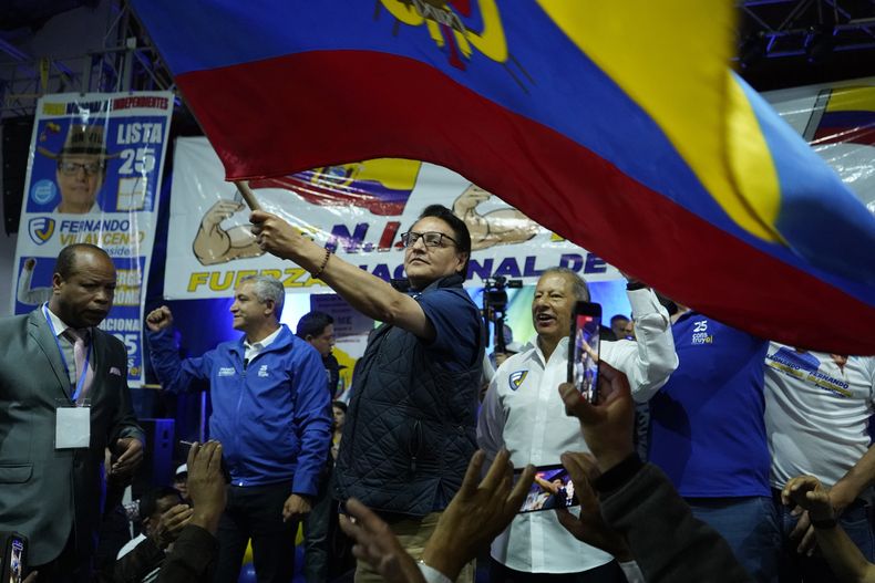 El candidato presidencial Fernando Villavicencio ondea una bandera de Ecuador en un acto de campaña en un colegio minutos antes de ser asesinado a tiros a la salida de ese recinto educativo en Quito, Ecuador, el miércoles 9 de agosto de 2023 (API vía AP)