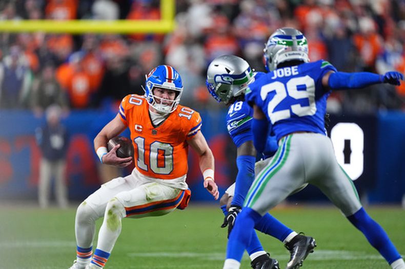 El quarterback de los Broncos de Denver, Bo Nix, a la izquierda, es captura por el apoyador de los Seahawks de Seattle, Tyrice Knight, al centro, y el esquinero Josh Jobe durante el tiempo extra de un partido de fútbol americano de la NFL, el jueves 15 de octubre de 2026, en Denver. (Foto AP/David Zalubowski)