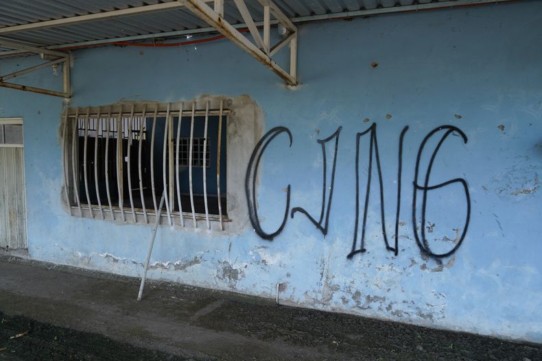 ARCHIVO – Las siglas del Cártel Jalisco Nueva Generación cubren la fachada de una vivienda abandonada en El Limoncito, en el estado mexicano de Michoacán, el 30 de octubre de 2021. (AP Foto/Eduardo Verdugo, Archivo)
