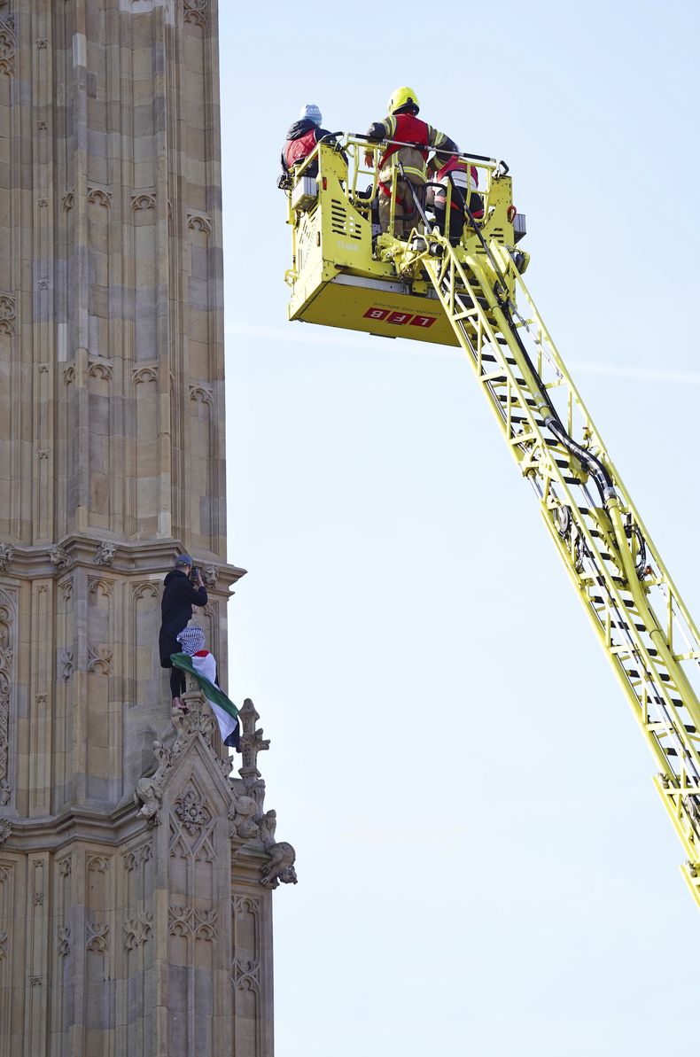 Un hombre con una bandera palestina, tras escalar la Torre Elizabeth, que alberga el Big Ben, en el Palacio de Westminster, el 8 de marzo de 2025, en Londres. (James Manning/PA vía AP)