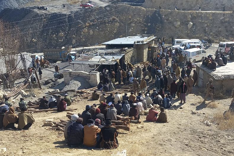 Vecinos de la zona se reúnen mientras los rescatistas trabajan para buscar a varios mineros tras una explosión de metano en una mina de carbón en Singidi, una zona remota de la provincia suroccidental de Baluchistán, en Pakistán, el viernes 10 de enero de 2025. (AP Foto)