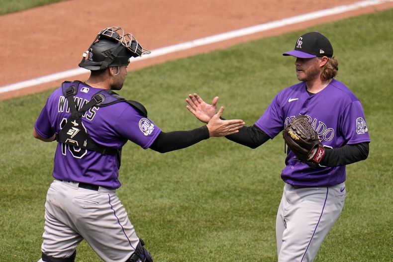 Pierce Johnson, derecha, relevista de los Rockies de Colorado, celebra con el receptor Austin Wynns después de sacar el último out del juego de béisbol en contra de los Piratas de Pittsburgh, en Pittsburgh, el miércoles 10 de mayo de 2023. Los Rockies ganaron 4-3. (AP Foto/Gene J. Puskar)