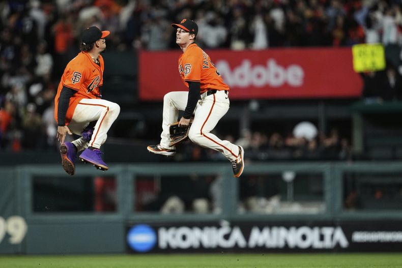 El dominicano Willy Adames y Mike Yastrzemski, de los Gigantes de San Francisco, festejan la victoria sobre los Dodgers de Los Ángeles, el viernes 11 de julio de 2025 (AP Foto/Godofredo A. Vásquez)