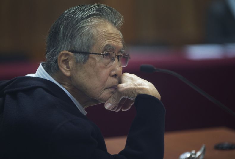 Archivo - El expresidente peruano Alberto Fujimori, fotografiado a través de una ventana, enfrenta un juicio en una estación policial en las afueras de Lima, Perú, el 28 de junio de 2016. Su hija, Keiko Fujimori, reportó el miércoles 26 de junio de 2024 que el exmandatario fue hospitalizado en una unidad de cuidados intensivos, a la espera de una cirugía larga y de riesgo, tras una caída. (AP Foto/Martín Mejía, File)