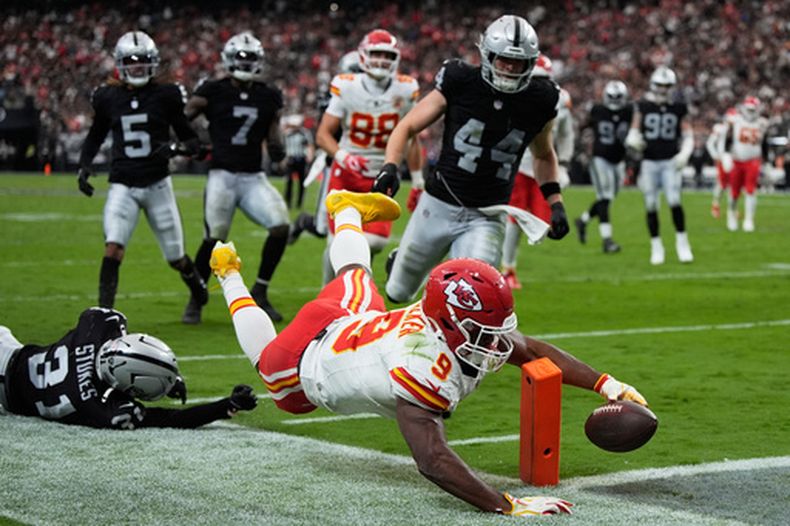 Kenneth Walker (9), corredor de los Chiefs de Kansas City, se lanza para conseguir un touchdown superando al profundo Treydan Stukes (31), de los Raiders de Las Vegas, durante la segunda mitad del partido de la NFL, el domingo 4 de octubre de 2026, en Las Vegas. (AP Foto/John Locher)