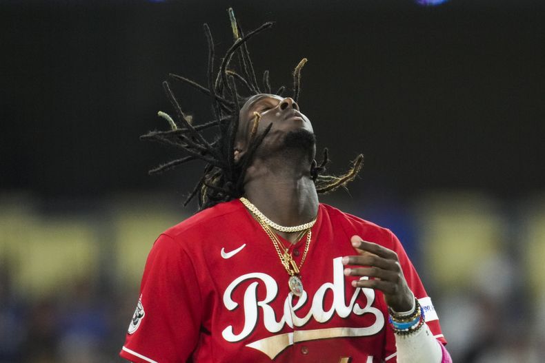 El dominicano Elly de la Cruz, de los Rojos de Cincinnati, se ajusta la gorra tras recibir un boleto intencional en el juego del viernes 28 de julio de 2023, ante los Dodgers de Los Ángeles (AP Foto/Ashley Landis)