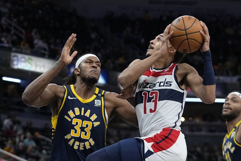 Jordan Poole (13), de los Wizards de Washington, ataca la canasta ante la marcación defensiva de Myles Turner (33), de los Pacers de Indiana, durante la segunda mitad del juego de baloncesto de la NBA, el miércoles 10 de enero de 2024, en Indianápolis. (AP Foto/Darron Cummings)