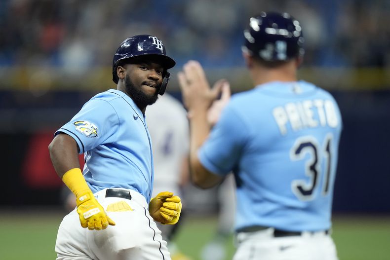 El venezolano Osleivis Basabe mira al coach de la inicial Chris Prieto, tras conectar un grand slam por los Rays de Tampa Bay en el juego ante los Rockies de Colorado, el martes 22 de agosto de 2023 (AP Foto/Chris OMeara)