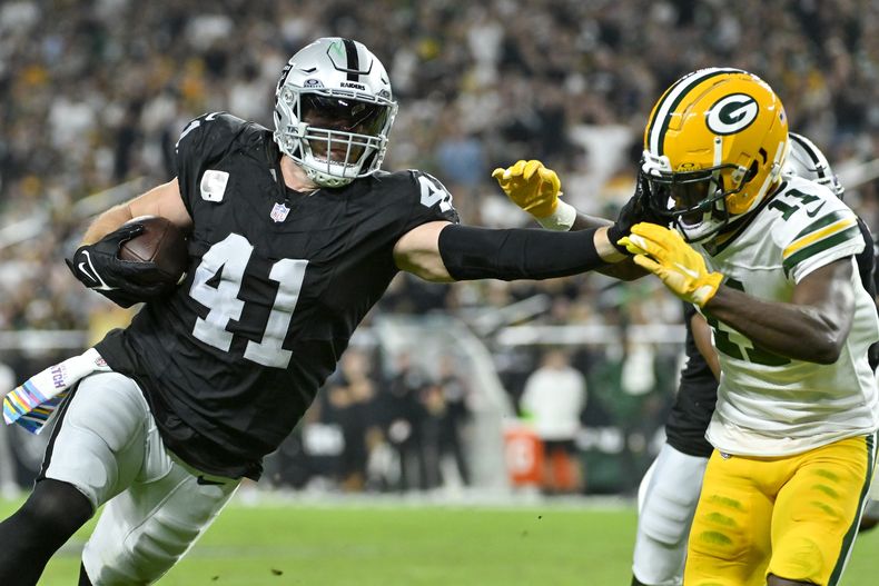 Robert Spillane de los Raiders de Las Vegas intenta superar a Jayden Reed de los Packers de Green Bay tras la intercepción en el encuentro del lunes 9 de octubre del 2023. (AP Foto/David Becker)