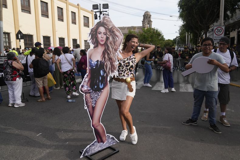 Una admiradora de la estrella de pop colombiana Shakira posa con un afiche de la cantante afuera del Estadio Nacional un día después de que canceló su concierto luego de ser hospitalizada, en Lima, Perú, el lunes 17 de febrero de 2025. (Foto AP/Martin Mejia)