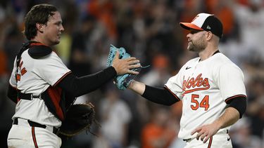 El relevista de los Orioles de Baltimore, Danny Coulombe (54), y el receptor Adley Rutschman, a la izquierda, celebran después de un partido de béisbol contra los Yankees de Nueva York, el lunes 29 de abril de 2024, en Baltimore. Los Orioles ganaron 2-0. (AP Foto/Nick Wass)